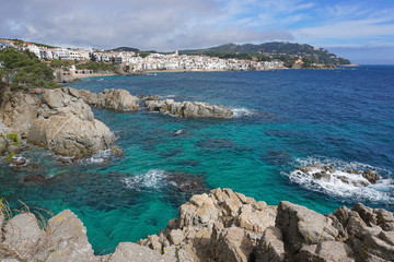 Fototapeta na wymiar Spain Mediterranean coast with rocks and the village Calella de Palafrugell in background, Costa Brava, Catalonia, Baix Emporda