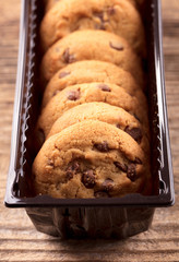 cookies in plastic box on wooden background
