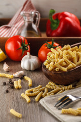 Italian raw pasta fusilli on the background of other ingredients for cooking