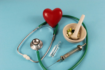 Pharmaceutical medicament,seringe , stethoscope and heart on blue background.