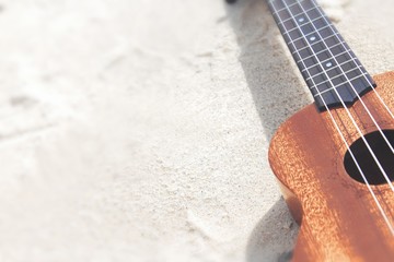 Ukulele guitar on a sand close up