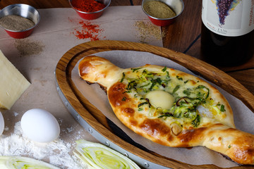 Deliciously served khachapuri with egg, cheese, herbs and spices in the restaurant.
