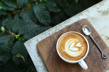 a cup of latte art coffee on wooden background