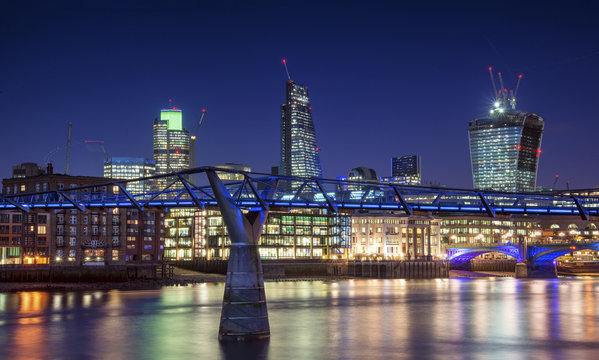 Beautiful London city night skyline landscape with glowing city lights reflected in River Thames