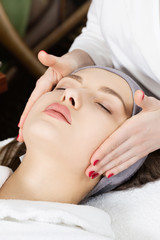 Obraz na płótnie Canvas Facial massage for a beautiful girl in a spa salon