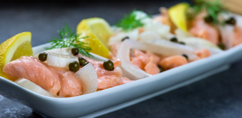 Salmon in a marinade of lemon juice with green pepper and onion - healthy food - closeup, banner