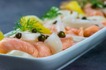Pieces, slices of raw salmon in a marinade of pure lemon juice - halthy meal - closeup