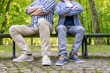 Angry couple sitting on the bench in the park.