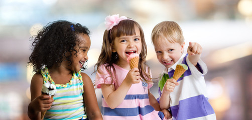 happy kids eating ice cream at a party in cafe