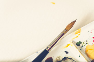 watercolor palette closeup and paint brush on white background 