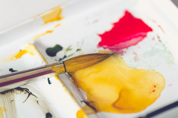 watercolor palette closeup and paint brush on white background 