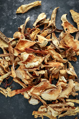 Dried porcini mushrooms on black background, texture.