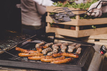 Cooking delicious juicy meat sausages on the grill outdoor