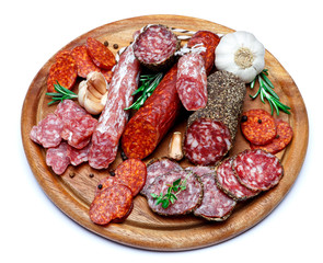 Various types of Dried organic salami sausage on wooden cutting board