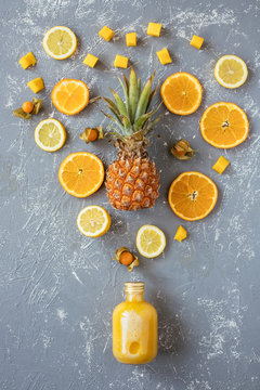 Sweet Yellow Smoothie With Pineapple, Citrus And Yellow Fruits On Gray Wooden Table, Top View