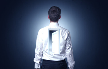 Young businessman standing and thinking with an open door on his back
