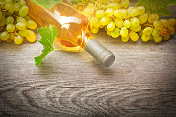 Bottle of white wine and grape  on wooden table