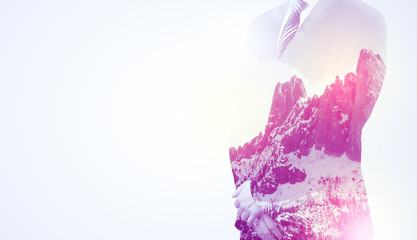  Young businessman in suit standing with sunny snowy mountain and trees graphic.