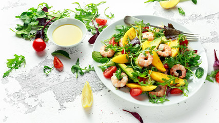 Fresh Avocado, Shrimps, Mango salad with lettuce green mix, cherry tomatoes, herbs and olive oil, lemon dressing. healthy food