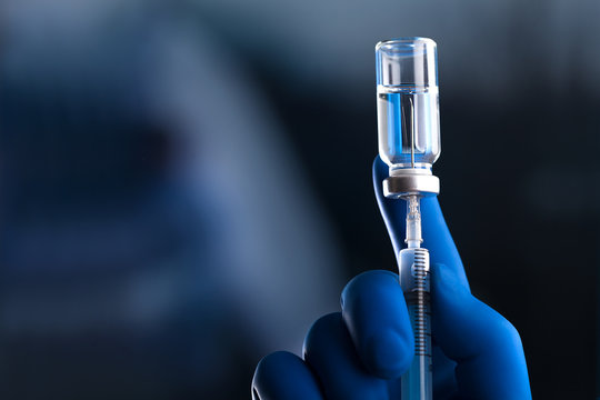 Doctor hand holds syringe and vaccine
