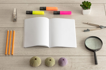 Empty notebook on wood floor with office tools nearby