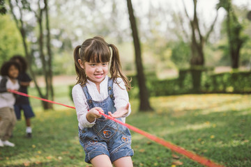 little girl children playing tug of war at the park