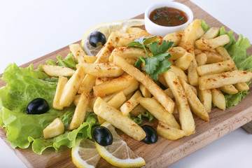 Tasty french fries on wooden board