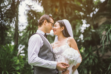 Groom and bride together. Wedding couple kiss and hug each other. focus on Flower bouquet