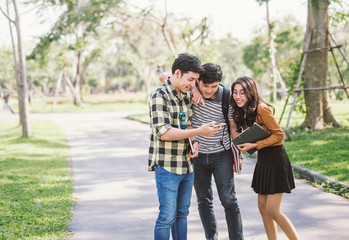 Group of cheerful friends watching the smart phone outdoor