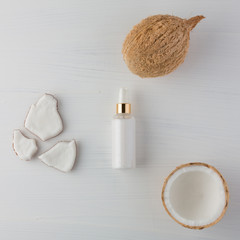 Homemade coconut products with half and whole coconut on white wooden table background. Oil, scrub, milk and lotion from top view. Good for space and background.