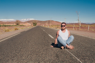 Fototapeta na wymiar sporty guy on the road in the desert