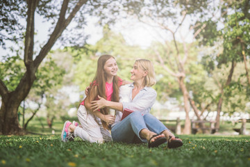 Fototapeta premium mom and daughter talking and hugging in park