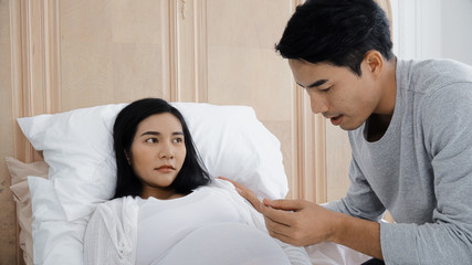 Young husband check digital thermometer to his wife pregnant