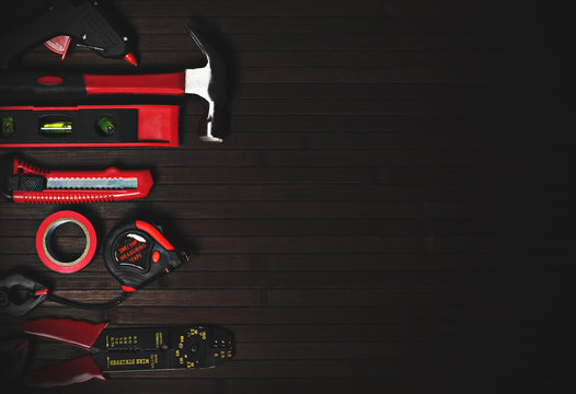 tools for home repair in red style on a black wooden background