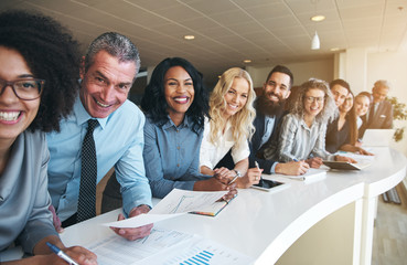 Coworkers in office smiling and looking at camera