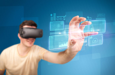 Young impressed man wearing virtual reality goggles with blue squares containing data at his fingers 