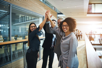 Multiethnic business people giving high five in office