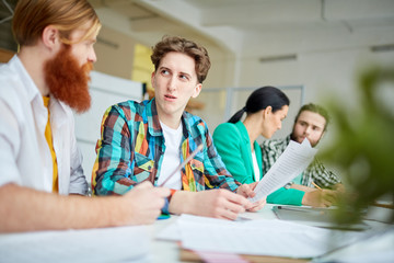 Business people sitting at the table and working with documents and discussing ideas