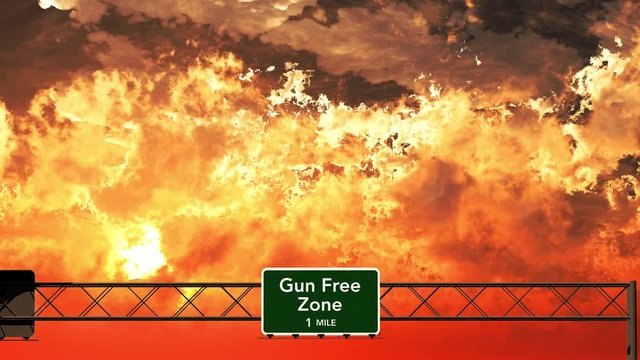 4K Passing USA Gun Free Zone Concept Sign in the Sunset