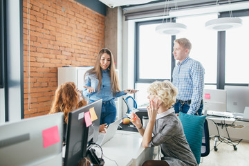 young beautiful active woman with long brown hair is explaining her plans about startup business to women and man. perspective idea of product development