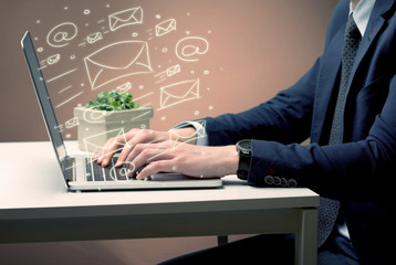 An office worker sending emails and communication with clients with the help of a portable laptop on desk concept
