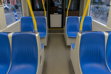 Tram inside, city transportation interior with blue seats yellow handles