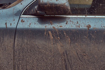 Close-up image of a dirty car after a trip around the countryside