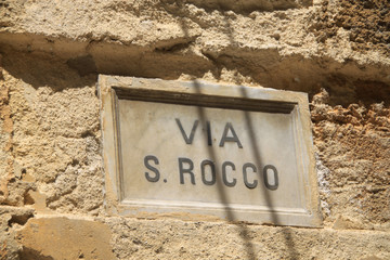 stara tabliczka z nazwą ulicy na ścianie budynku we woszech