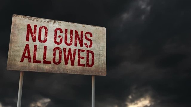4K No Guns Allowed Control Rusty Sign under Clouds Timelapse