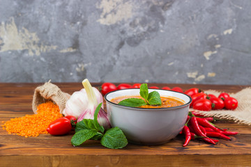 Red lentil soup with food, front view. With space for text.