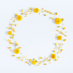 Flowers composition. Wreath made of yellow flowers on pastel blue background. Flat lay, top view, square, copy space