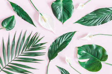 Obraz premium Summer tropical composition. Green tropical leaves and white flowers on pink background. Summer concept. Flat lay, top view