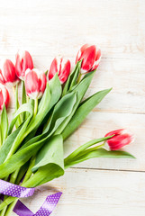 Background for congratulations, greeting cards. Fresh spring tulips flowers, on white wooden background top view copy space