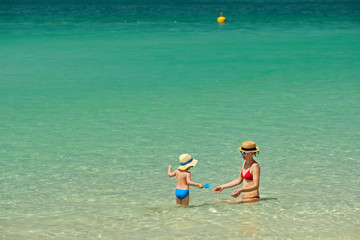 Toddler boy on beach with mother